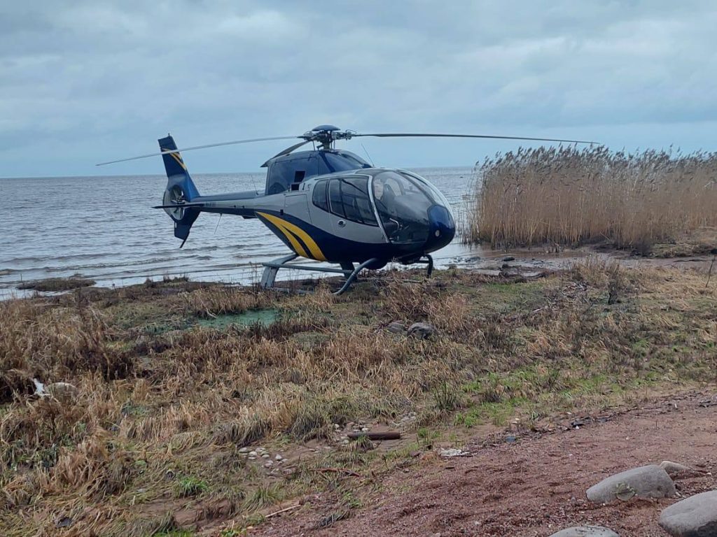 Вертолет сел на берегу Финского залива у кромки воды